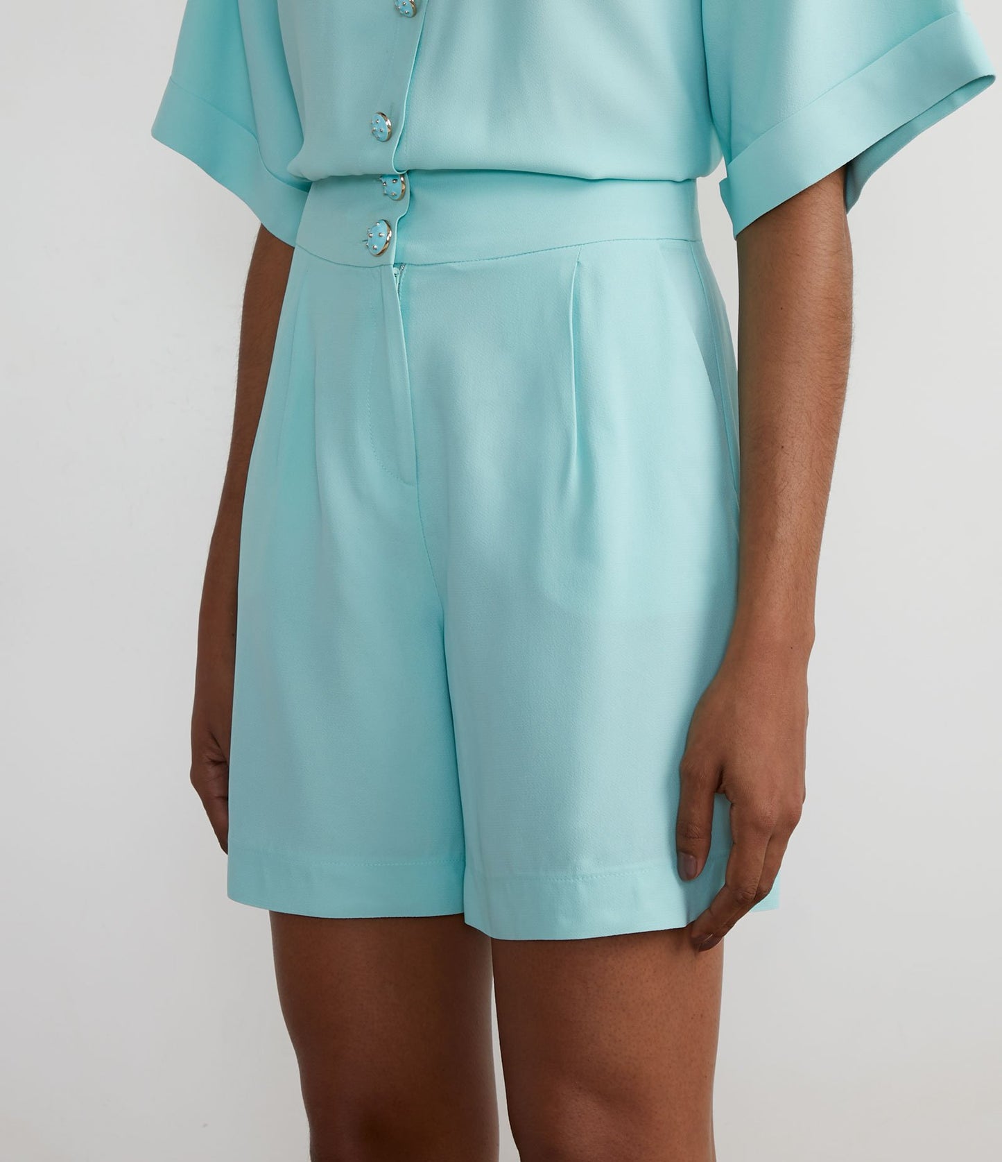 Bermuda in crepe con bottoni unici e pieghe frontali in verde