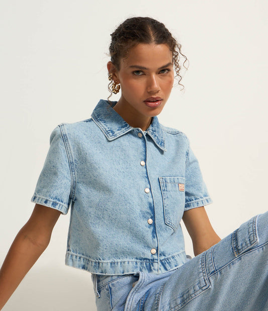 Camicia di jeans blu con tasca frontale e chiusura a bottoni