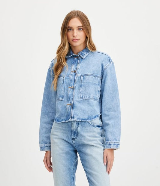 Camisa de brim azul com bolsos frontais e mangas amplas