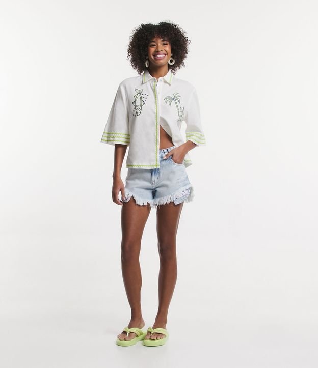 Shorts jeans com detalhes desgastados e forro de bolso azul estampado