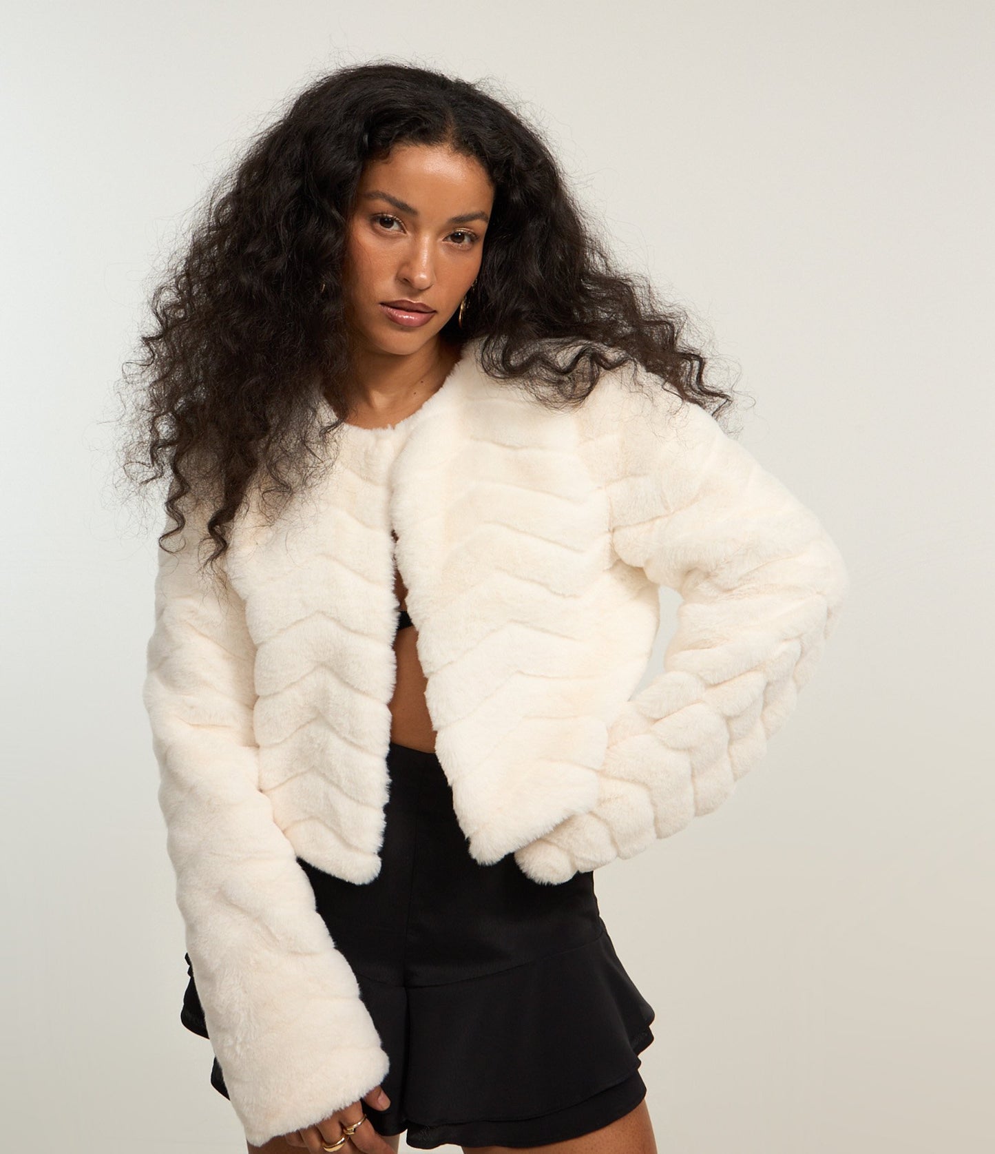 Cappotto corto in pelliccia sintetica con chiusura a gancio in bianco