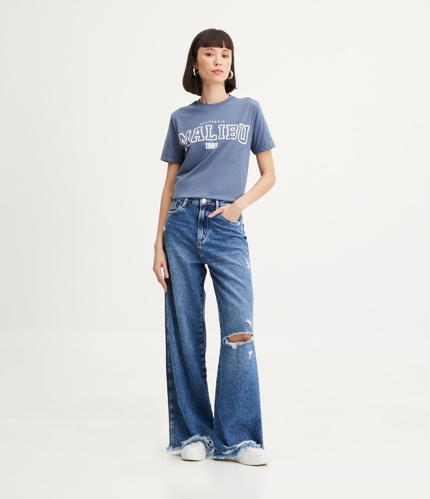 Calça jeans de perna larga com bolsos listrados e detalhes desgastados em azul