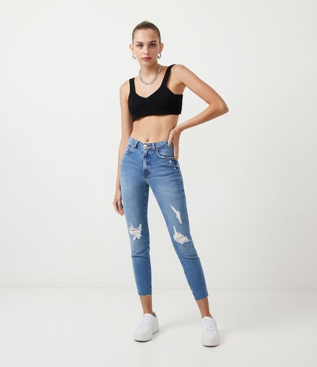 Calça jeans skinny azul com rasgos no joelho