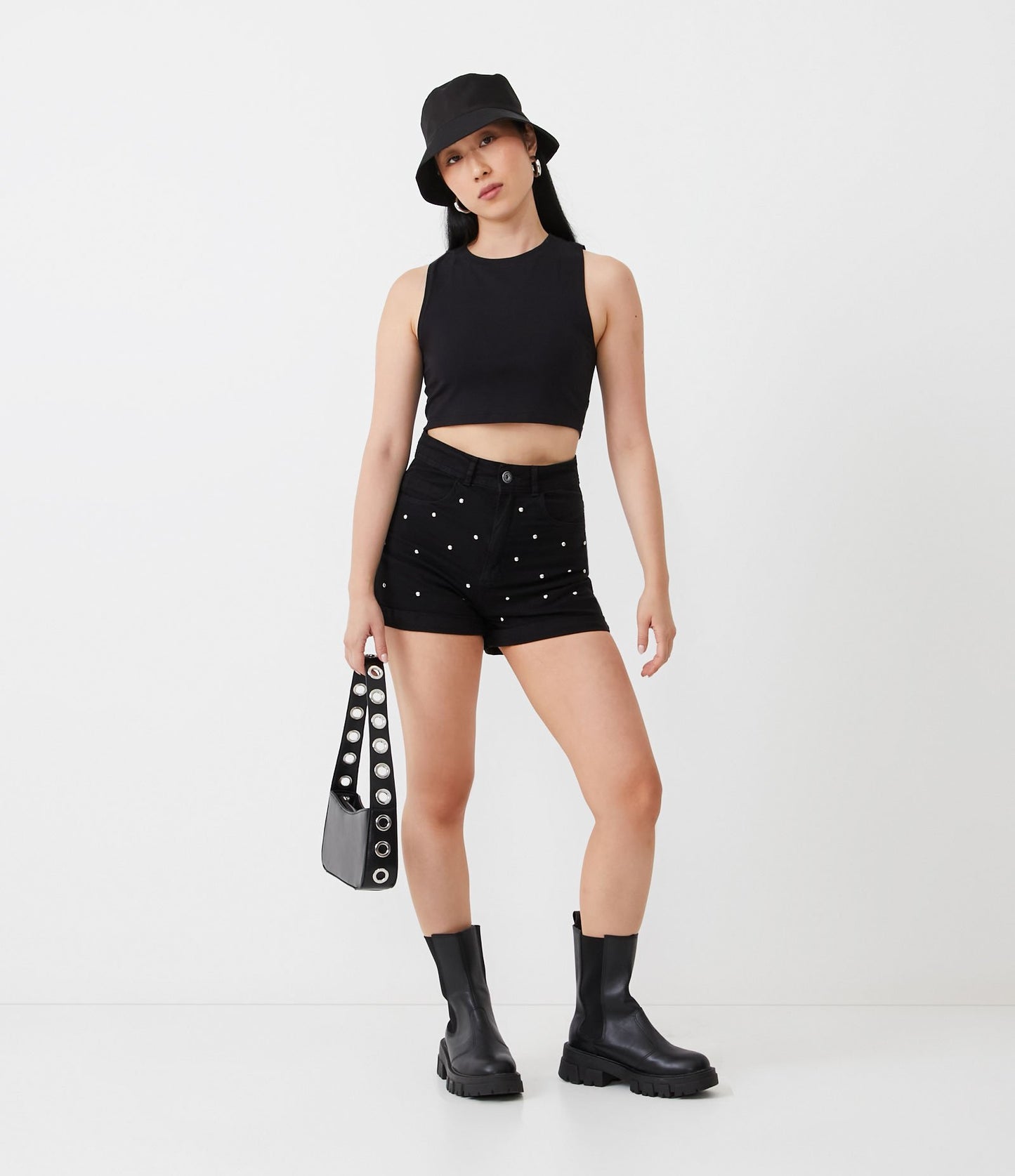 Calça de brim preta com tachas e bainha enrolada