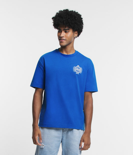 Camiseta azul em tecido de malha macia com estampa de brasão no peito