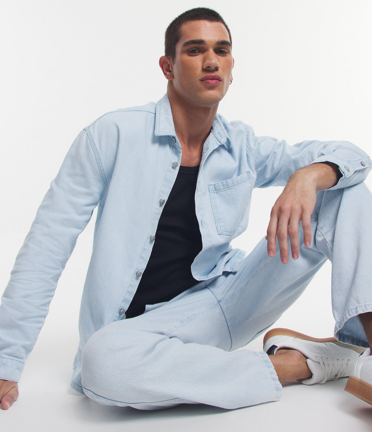Camisa de brim azul com botões na frente e bolso no peito