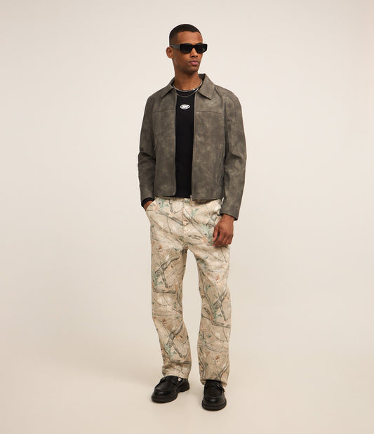 Pantaloni in twill beige con stampa di rami d'albero