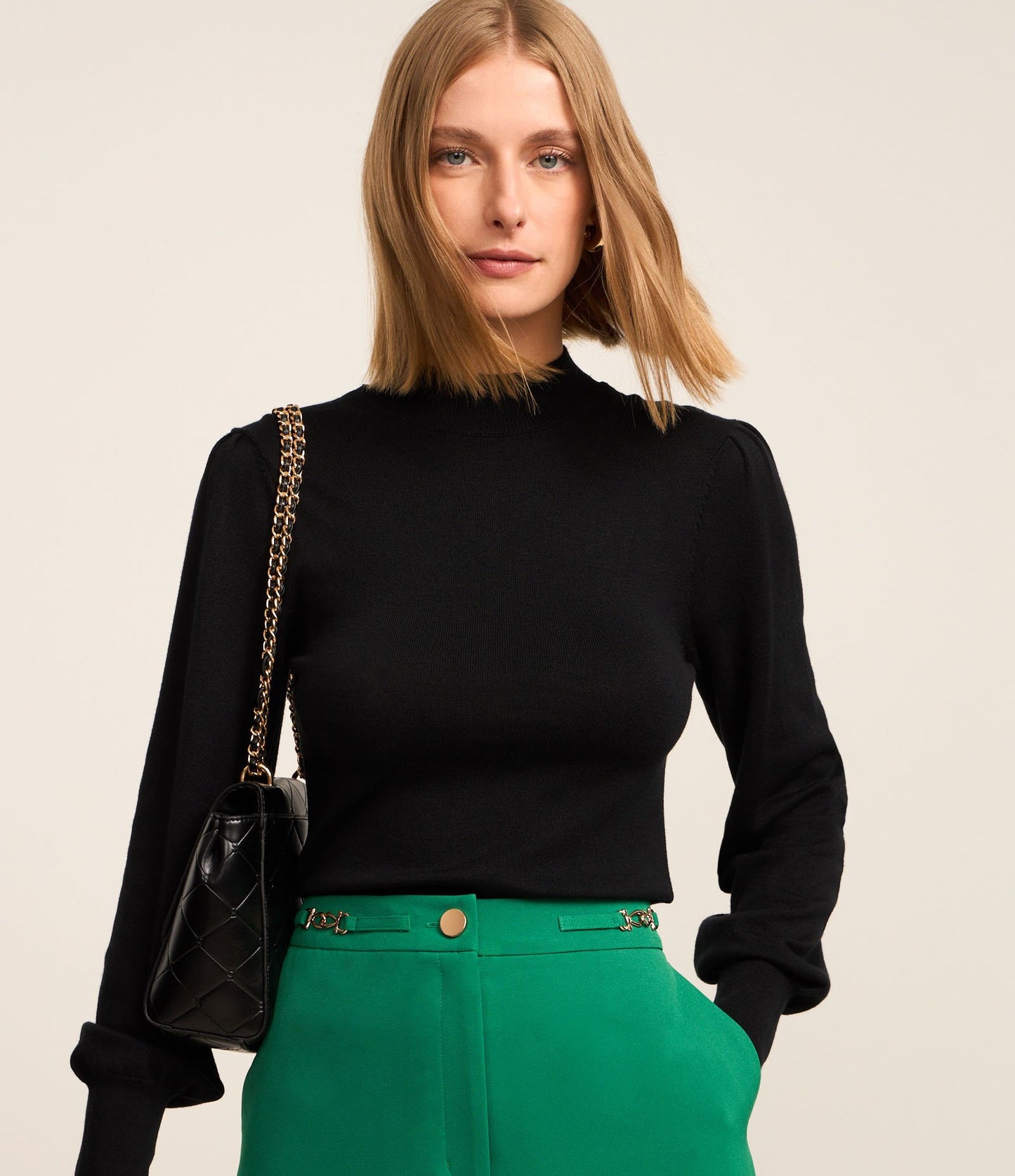 Maglione nero a maglia con collo alto e maniche a sbuffo