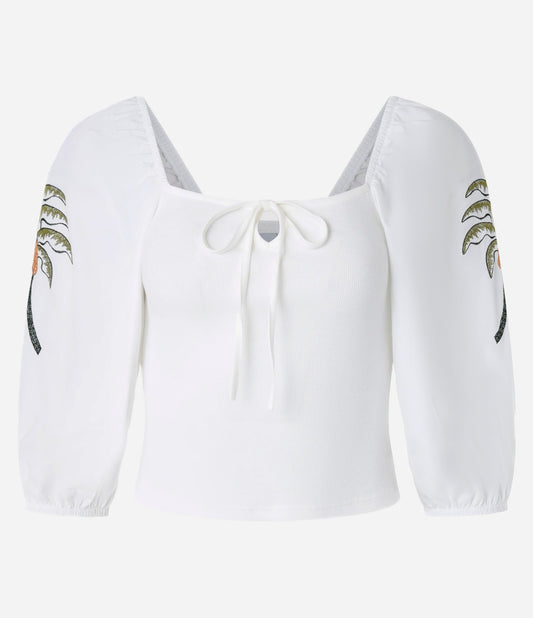 Blusa blanca de canalé con lazo y bordado tropical en las mangas