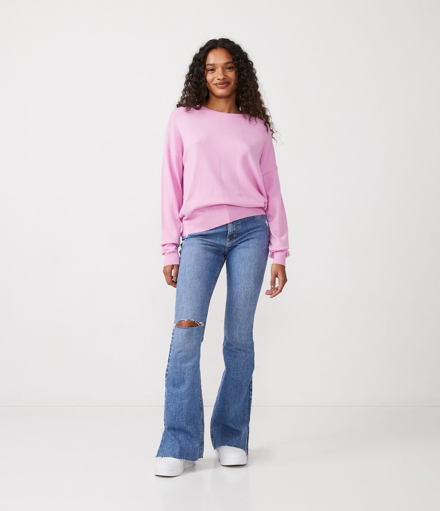 Jeans com corte de bota com rasgos no joelho e fendas azuis