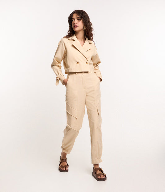 Calça de sarja bege com ajuste em cenoura e bolso na diagonal