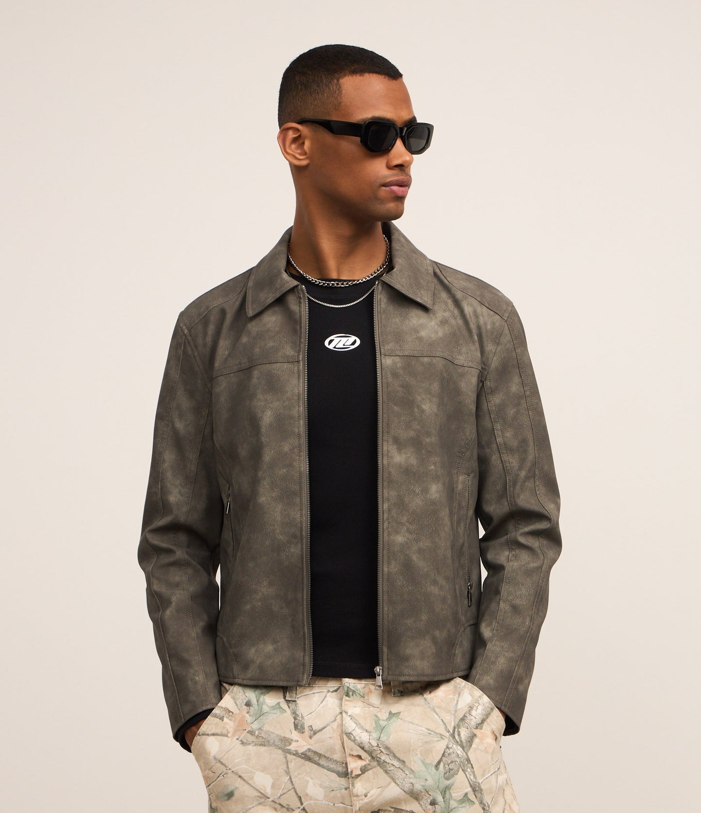 Giacca in materiale sintetico con ritagli e stampa a macchie verdi