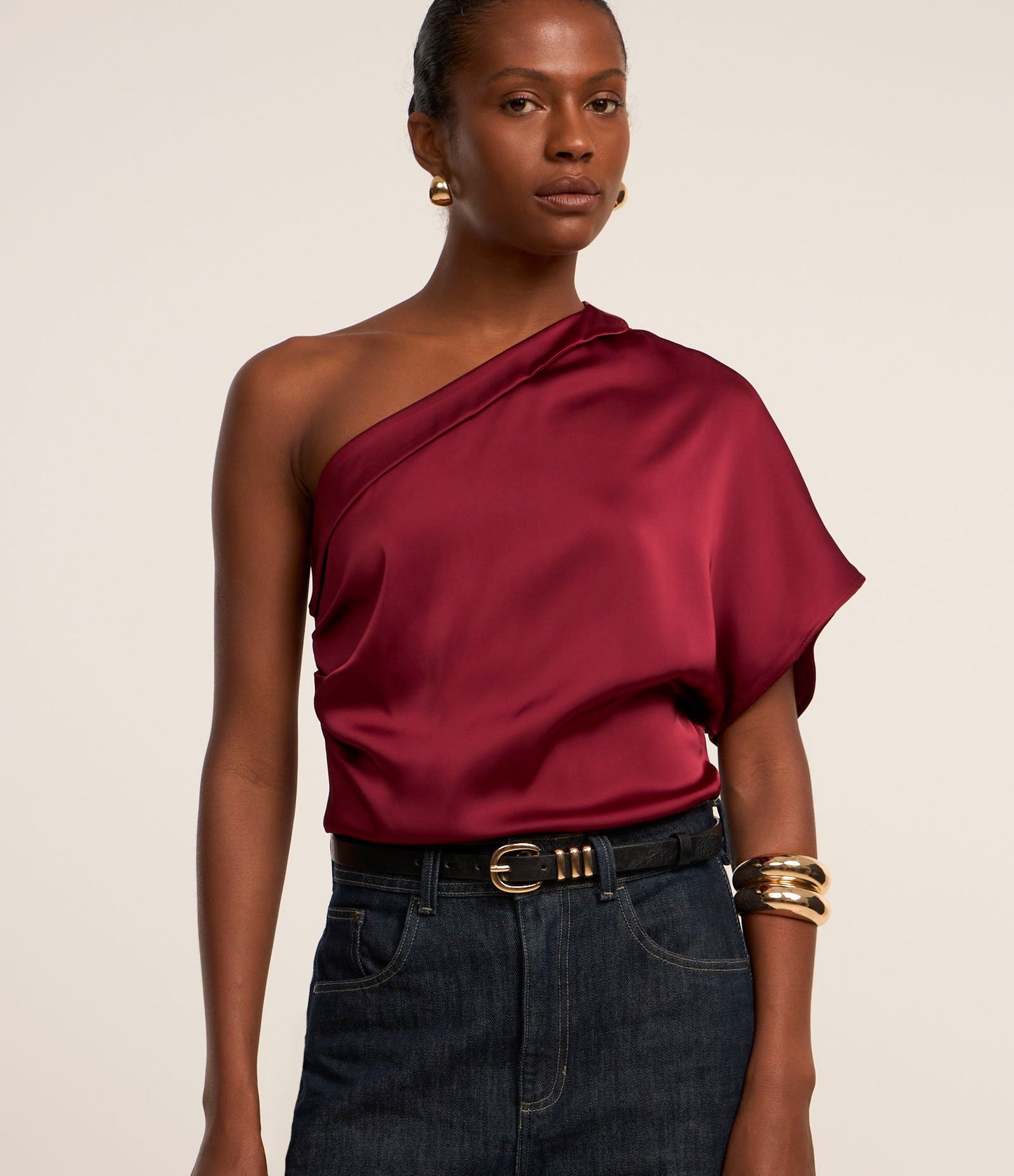 Blusa roja de satén con un hombro y drapeado lateral